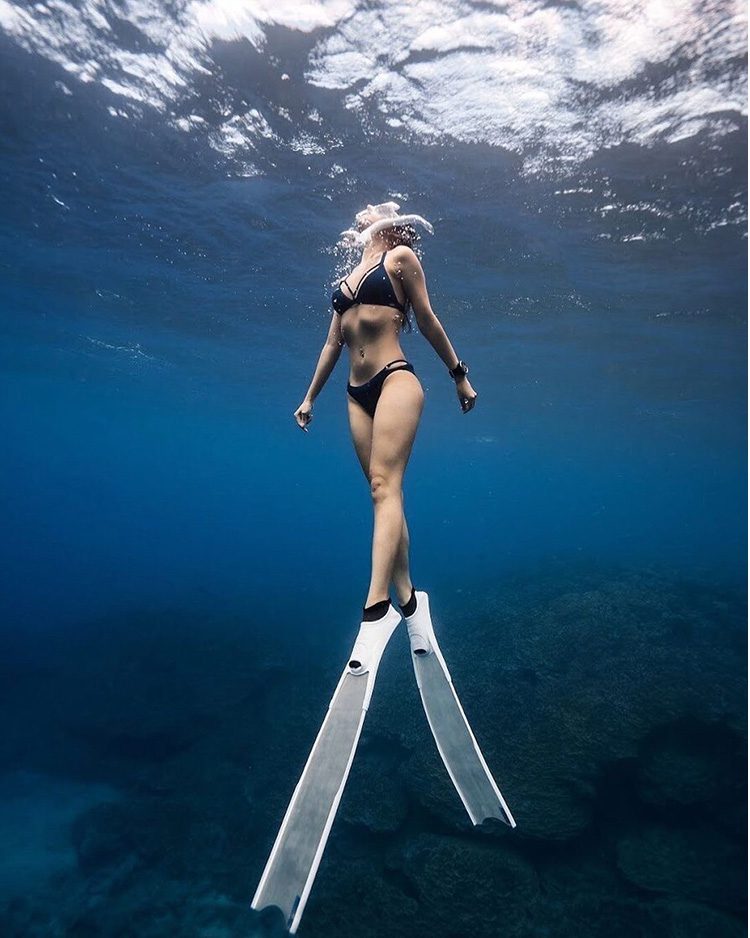 A girl with webbed feet in the deep sea