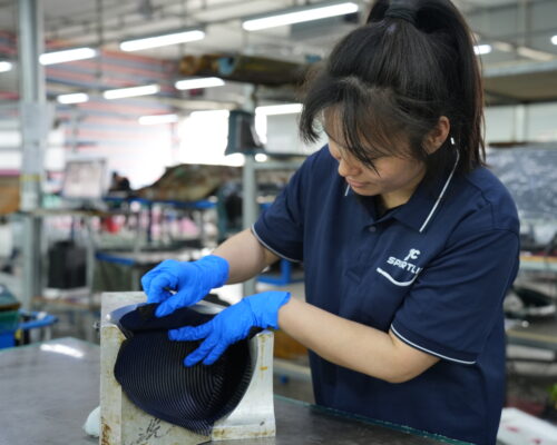 Close-up view of carbon fiber layers being applied to a mold
